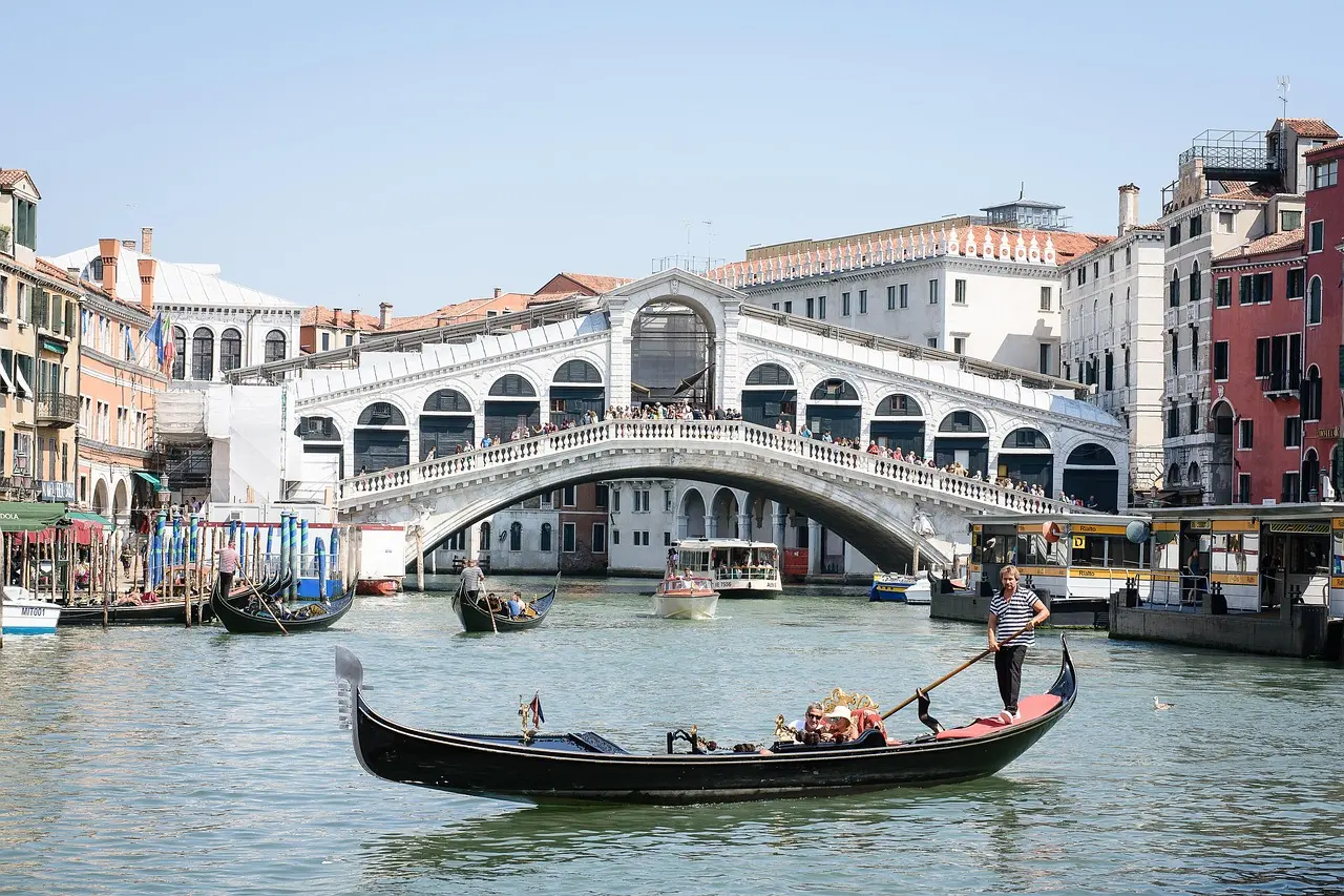 Misty dawn over the Rialto Bridge in Venice — a dreamlike, atmospheric highlight among must-visit places in Italy Fog-draped Rialto Bridge at dawn with gondolas gliding beneath in Venice
