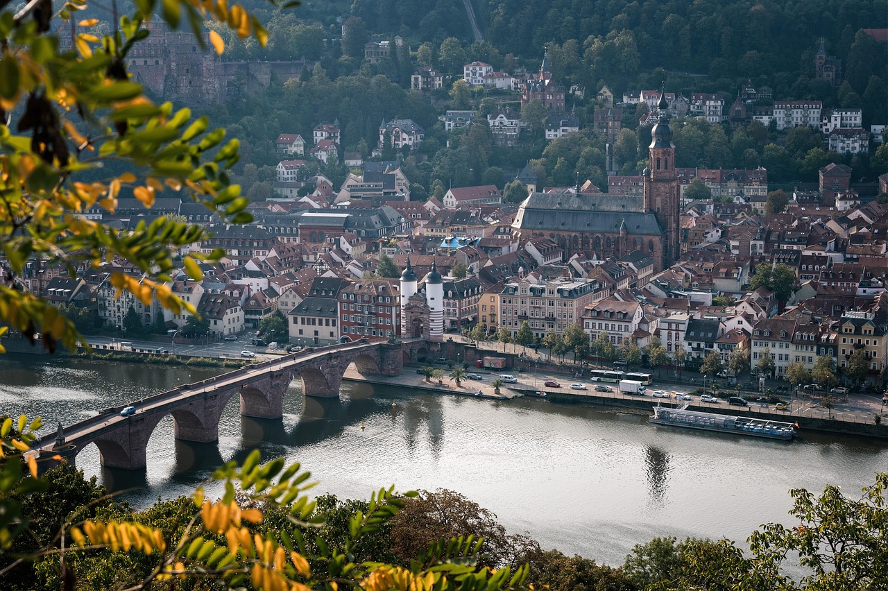 Heidelberg Castle silhouetted against a fiery sunset, gazing down on the winding Neckar River and the honey-hued rooftops of Germany’s oldest university town — a poetic inclusion among the 15 must-visit places in Germany. Heidelberg Castle overlooking the Neckar River and red-roofed old town at sunset