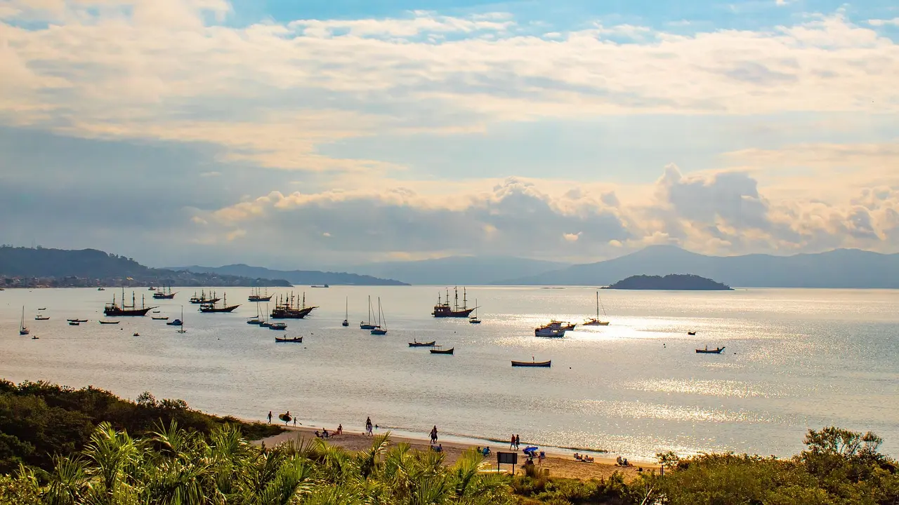 Aerial panorama of Florianópolis Island showing golden-sand beaches, emerald lagoons, and rolling forested hills — a microcosm of Brazil’s coastal diversity in southern Brazil Aerial view of Florianópolis island with beaches, lagoons, and green hills