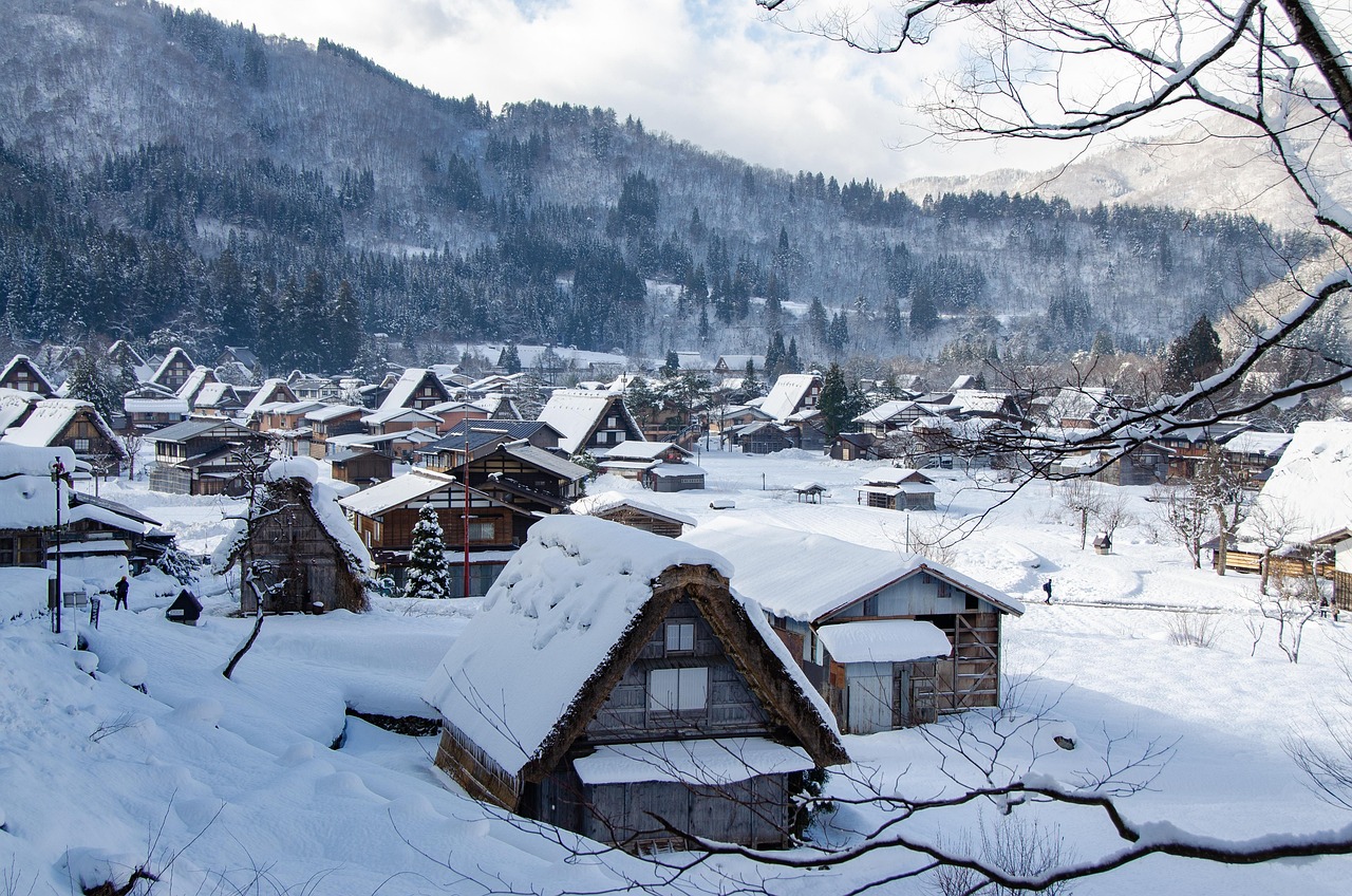 Snow-laden gassho-zukuri houses in Shirakawa-go illuminated at dusk — a magical, UNESCO-protected highlight among the most scenic places to visit in Japan Shirakawa-go village at dusk with snow-covered gassho-style thatched roofs and warm interior lights