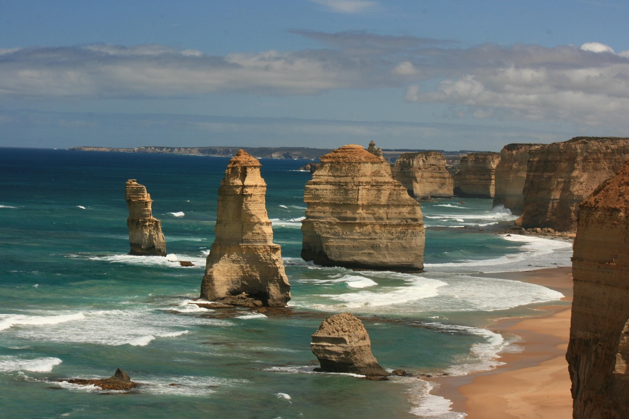 The towering Twelve Apostles silhouetted against a fiery sunset, waves exploding at their bases — a defining image of Victoria’s wild southern coastline Twelve Apostles limestone stacks at sunset with crashing waves