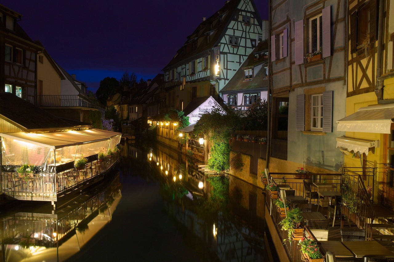 Quaint timber-framed houses with flower-filled balconies lining the peaceful Lauch River in Colmar’s ‘Little Venice’ district La Petite Venise district in Colmar with timber-framed houses and canal boats