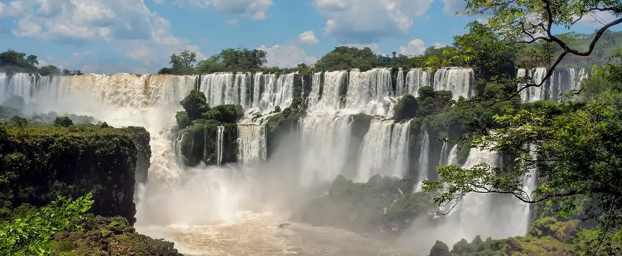 Aerial perspective of Iguazu Falls’ roaring cascades cutting through dense Atlantic rainforest in southern Brazil — a UNESCO World Heritage marvel of hydrological force and biodiversity Aerial shot of Iguazu Falls’ cascading water and surrounding rainforest canopy