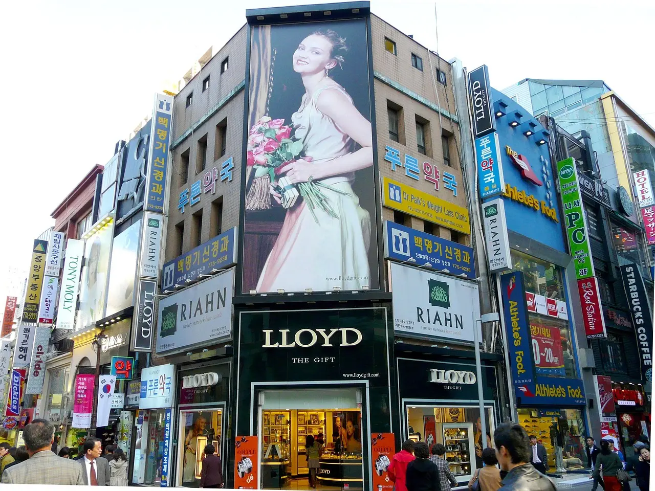 Lively Myeongdong at night — one of Korea’s most iconic urban experiences and essential places in Korea for food, fashion, and fun Crowded Myeongdong street at night with glowing signs, food stalls, and shoppers