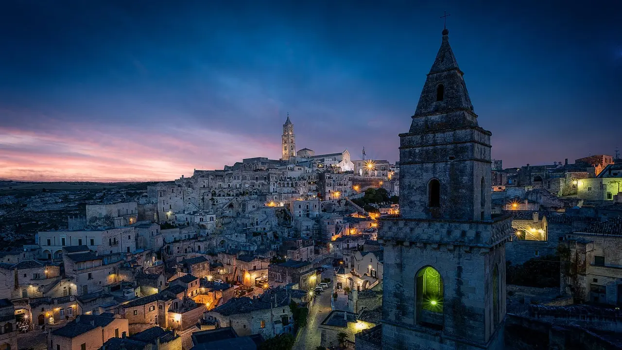 Golden sunset illuminating Matera’s ancient Sassi cave dwellings — a hauntingly beautiful UNESCO treasure among must-visit places in Italy Sunset over Matera's Sassi district with honey-colored cave dwellings cascading down limestone ravine