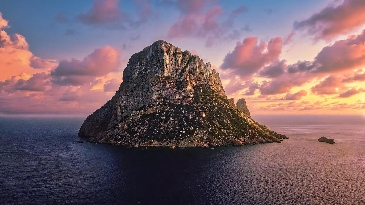 The ethereal silhouette of Es Vedrà at sunset — a sacred islet off Ibiza’s coast, symbolizing the island’s mystical allure among must-visit places in Spain. Sunset over Es Vedrà island from Cala d’Hort beach in Ibiza