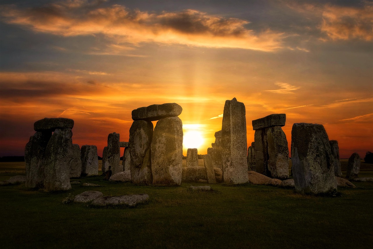 Ancient standing stones of Stonehenge silhouetted against a soft dawn sky in Wiltshire