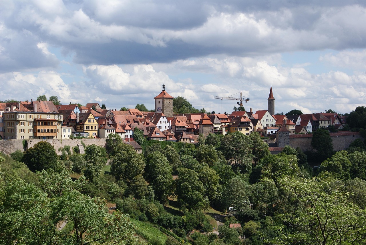The storybook silhouette of Rothenburg ob der Tauber at twilight — terracotta rooftops, timber-framed gables, and the iconic Plönlein junction — a beloved highlight among the 15 must-visit places in Germany. Rothenburg ob der Tauber’s medieval old town with red-tiled roofs and clock tower at dusk