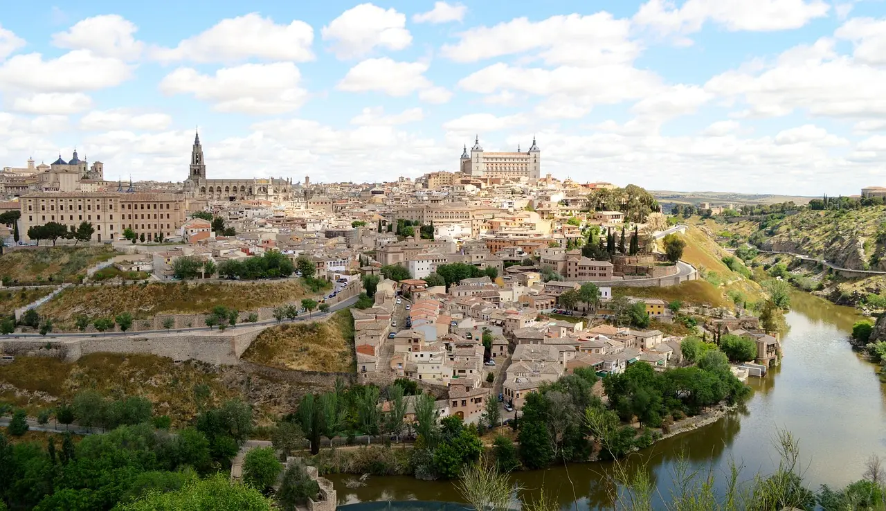 Toledo’s storied silhouette — a testament to coexistence and craftsmanship, securing its status as one of Spain’s most historically resonant must-visit places in Spain. Toledo’s historic skyline with cathedral, Alcázar, and medieval bridges over the Tagus River