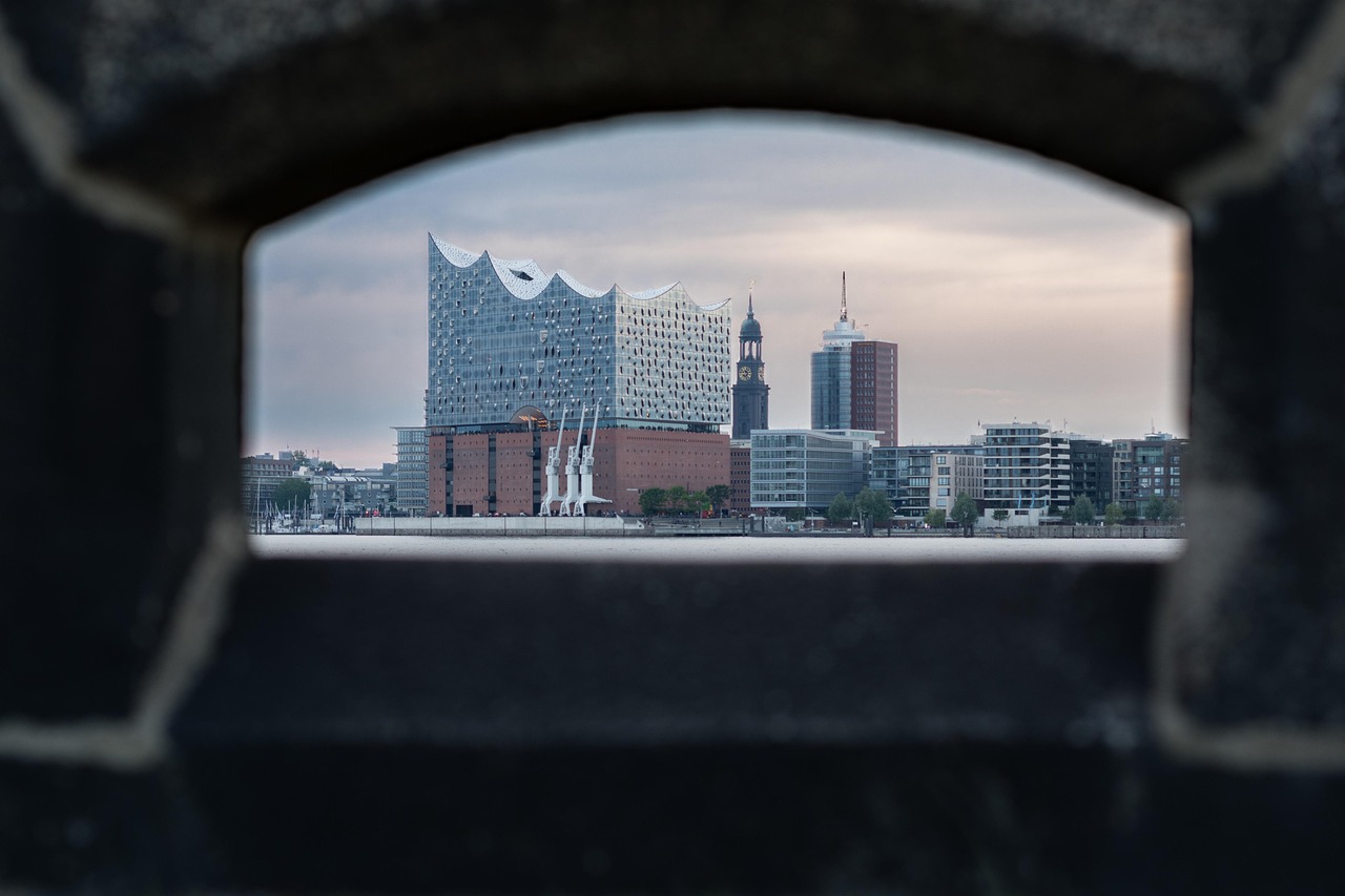 The futuristic Elbphilharmonie mirrored in the Elbe River, juxtaposed with Speicherstadt’s historic red-brick warehouses — a bold fusion of old and new among the 15 must-visit places in Germany. Elbphilharmonie concert hall reflecting in the Elbe River beside historic brick warehouses