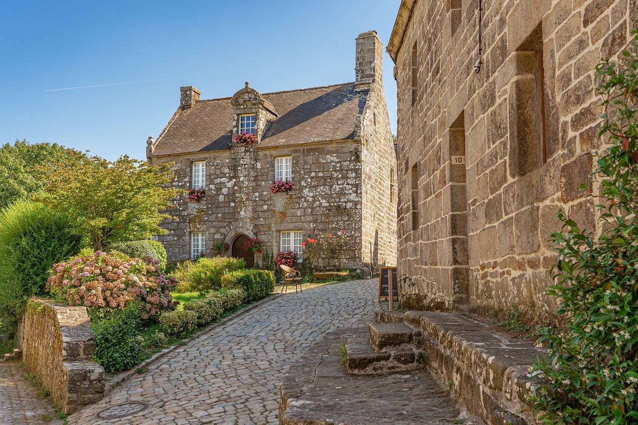 Sunlit cobblestone path winding through traditional mud-brick dwellings and shaded courtyards in Hatta Heritage Village, surrounded by rugged Hajar Mountains Traditional mud-brick houses and stone pathways in Hatta Heritage Village