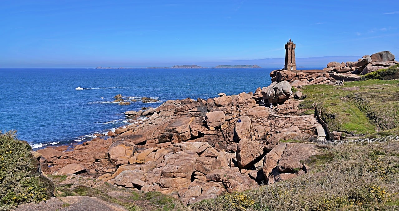 Uniquely weathered pink granite boulders scattered along a rocky Atlantic shoreline in northern Brittany, France Pink granite boulders shaped by wind and sea on Brittany's coast