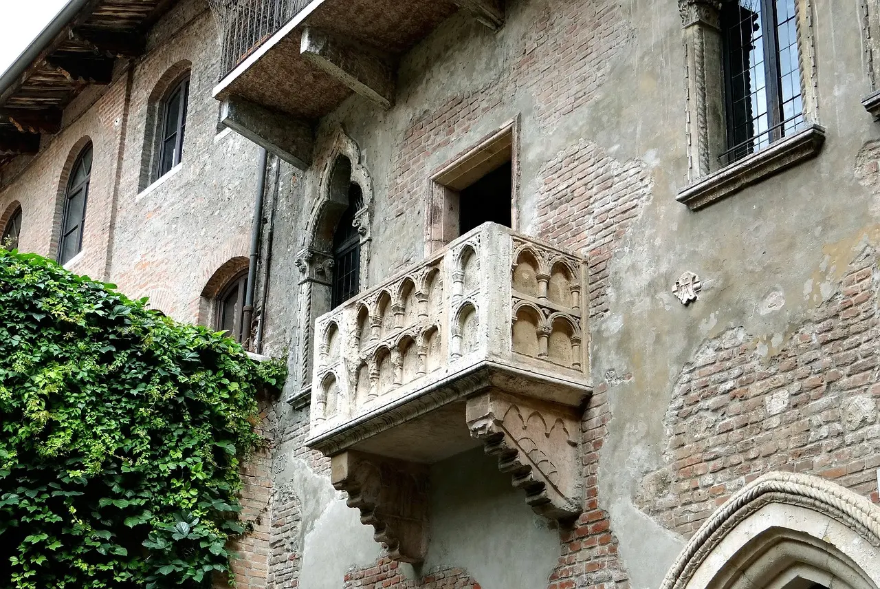 Juliet’s famous balcony in Verona’s Casa di Giulietta — a poetic, flower-draped landmark among must-visit places in Italy Juliet's balcony at Casa di Giulietta in Verona with flower-filled courtyard and engraved love notes on walls