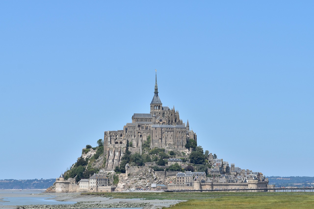 Aerial perspective of Mont Saint-Michel isolated in the sea during high tide, showcasing its dramatic coastal setting in northwestern France Aerial view of Mont Saint-Michel surrounded by ocean at high tide