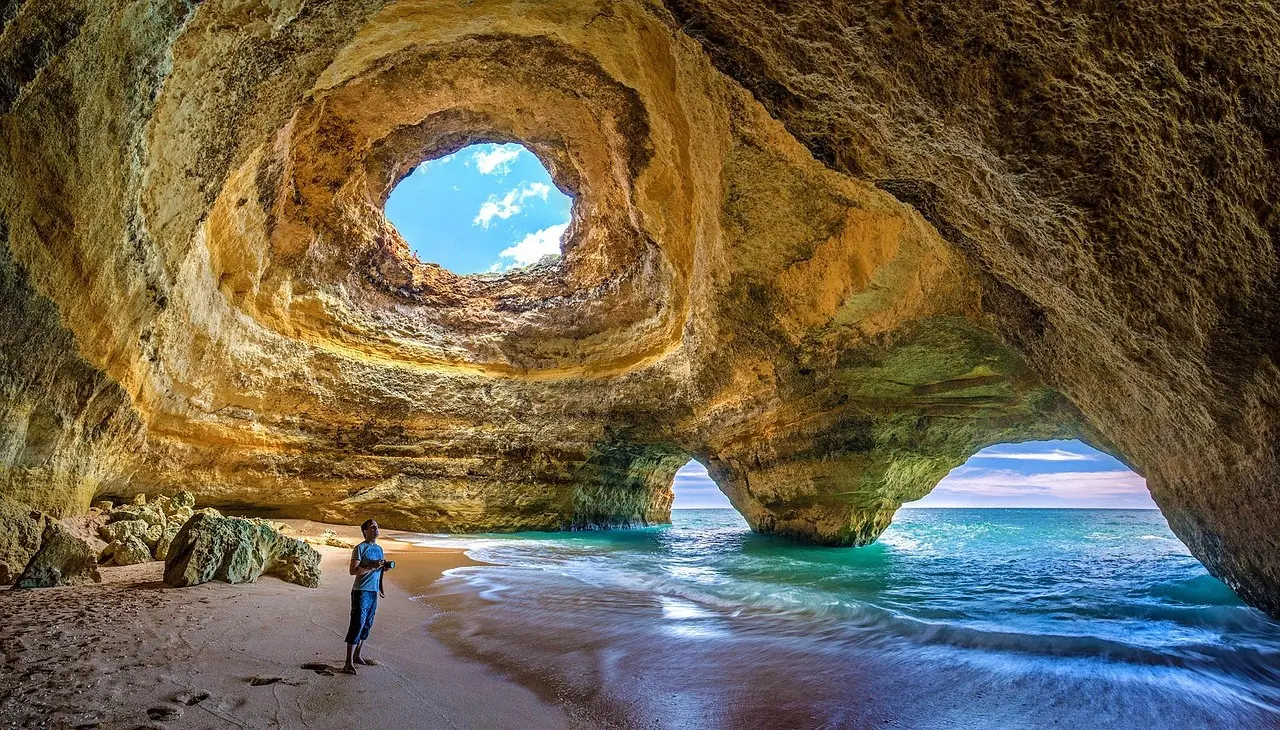 Sunlight piercing through the ceiling of Benagil Cave in the Algarve, illuminating emerald and turquoise waters inside the limestone grotto Benagil Cave’s sea entrance with sunlight streaming through the dome onto turquoise water