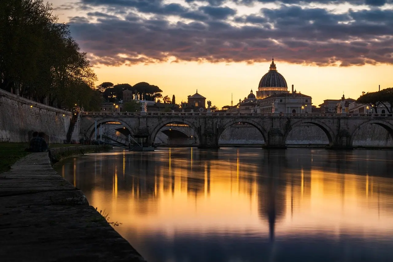 Golden morning light illuminates the dome of St. Peter's Basilica in Vatican City, Rome — a defining symbol among must-visit places in Italy Sunrise view of St. Peter's Basilica dome with soft golden light over Rome rooftops