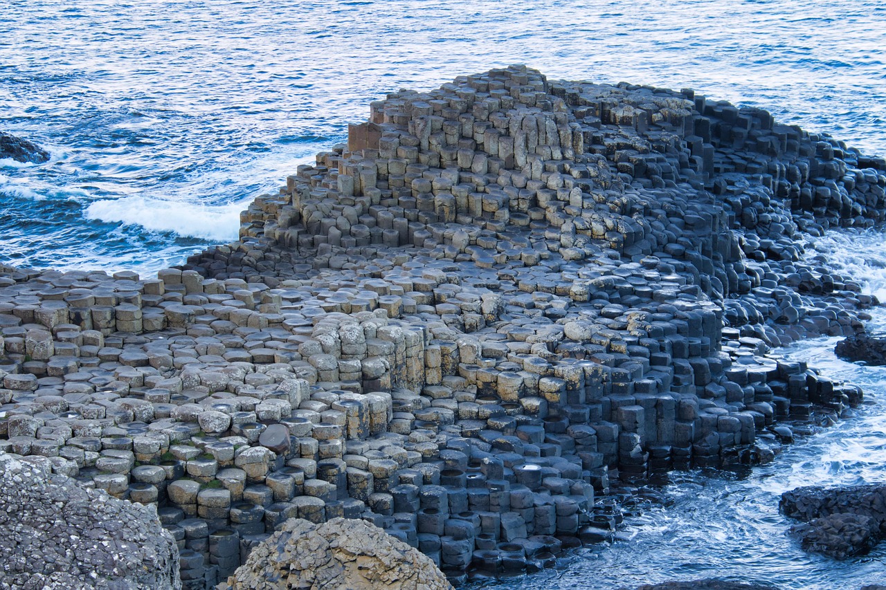 Otherworldly geometry of Giant’s Causeway — a natural marvel and essential stop among must-visit places in the UK Hexagonal black basalt columns of Giant's Causeway meeting crashing ocean waves
