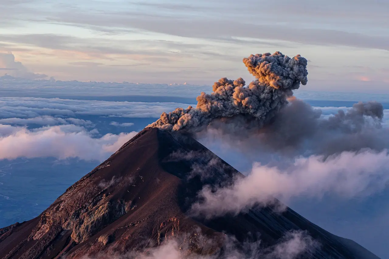 Mount Teide at dawn — its colossal presence casting long shadows over ancient lava flows, a breathtaking highlight among must-visit places in Spain. Mount Teide volcano at sunrise with snow-capped peak and dramatic shadows over lava fields