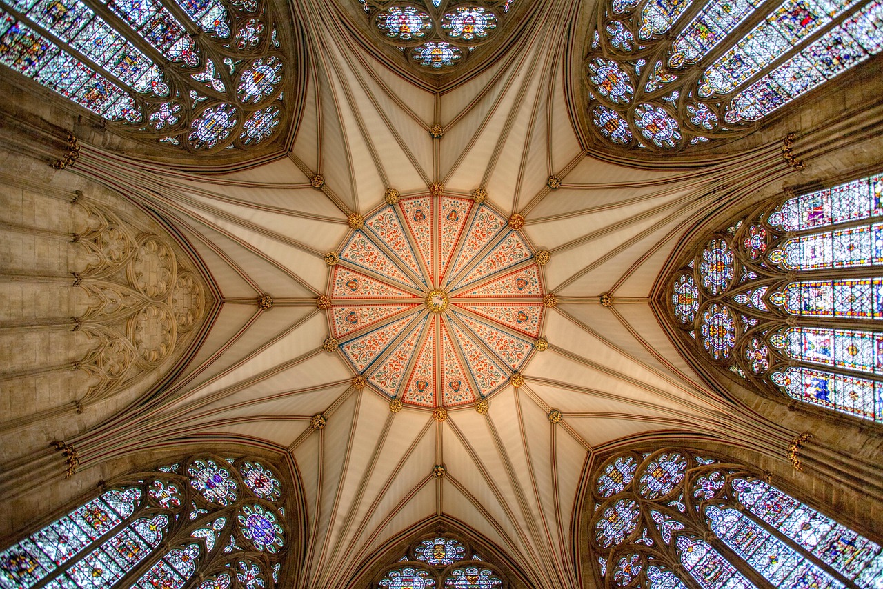 Divine light filters through centuries-old stained glass in York Minster — a spiritual highlight among must-visit places in the UK Sunlight streaming through intricate stained-glass windows inside York Minster