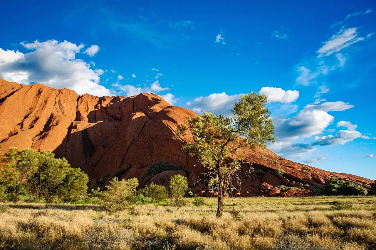 Uluru (Ayers Rock) mostrando sus vibrantes tonos rojos al atardecer en el desierto australiano Uluru al atardecer con colores rojizos intensos
