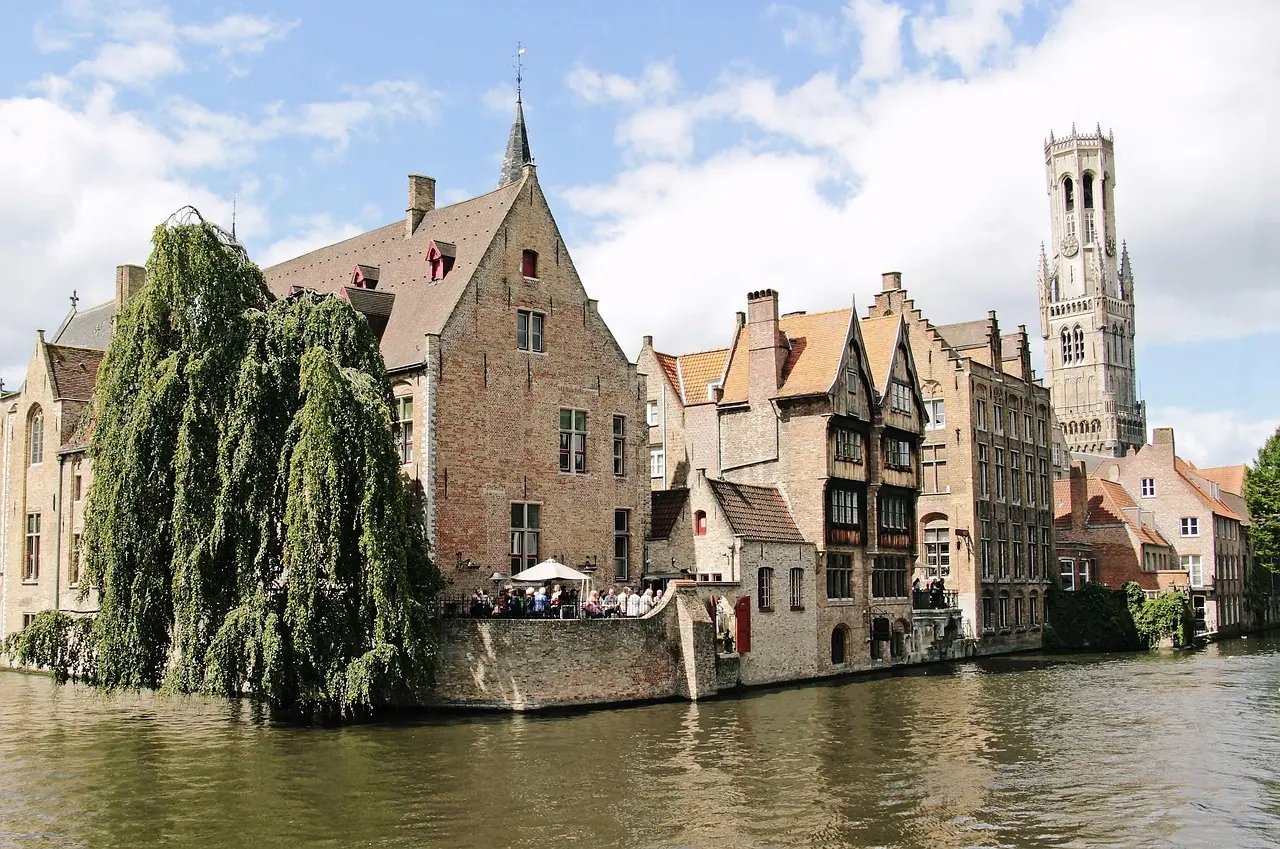 Peaceful Bruges canal scene — a storybook-perfect European honeymoon destination Canal in Bruges with medieval buildings, swans, and arched stone bridge under soft daylight