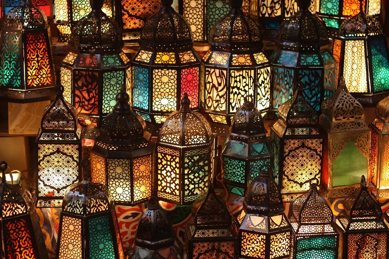 Khan El Khalili in Cairo: A centuries-old, atmospheric shopping destination for travelers drawn to heritage, craft, and storytelling Sun-dappled alley in Khan El Khalili with hanging brass lanterns, spice sacks, and artisan metalwork