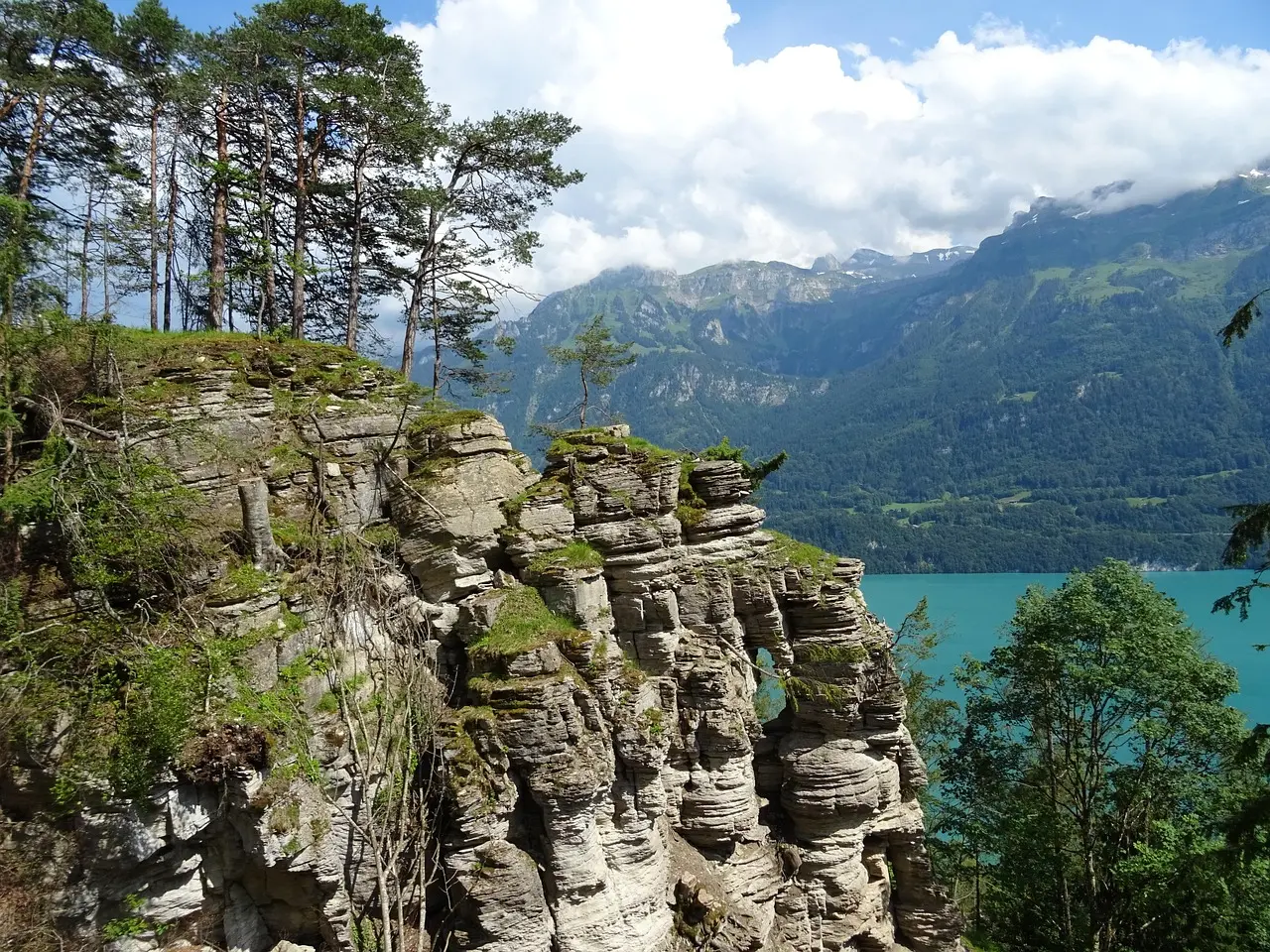 Escalador en pared rocosa vertical con paisaje montañoso