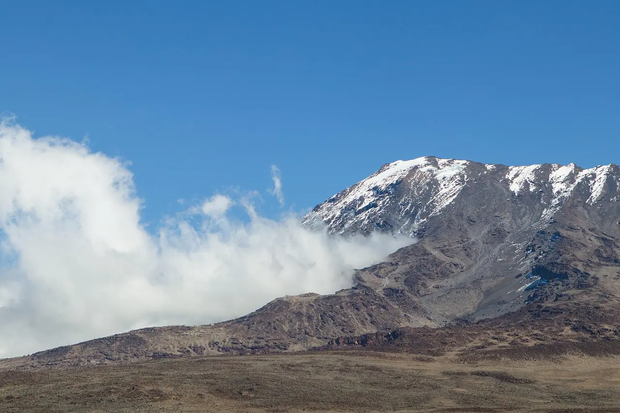 Montañista en cima del Kilimanjaro al amanecer