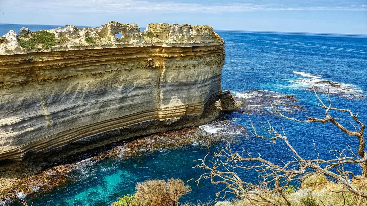 Sunset drama along the Great Ocean Road — where geology, ocean, and light converge for unforgettable appreciation of natural scenery Twelve Apostles limestone stacks at sunset, waves crashing violently against their bases on Australia's Great Ocean Road