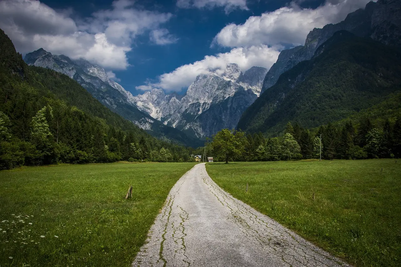 Electric mountain biker enjoying scenic descent along Vršič Pass with the turquoise Soča River far below E-bike rider on winding alpine road overlooking Soča River valley with emerald water and limestone cliffs