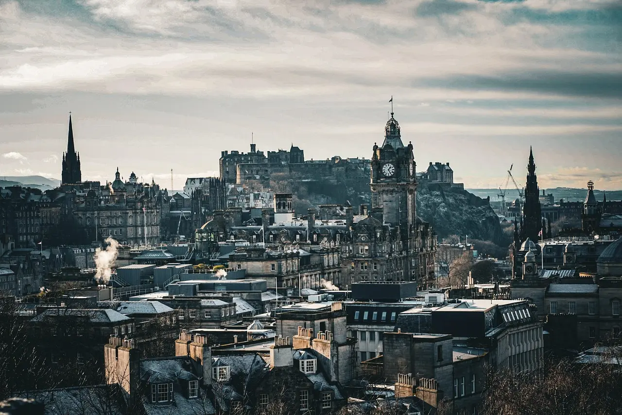 Vista del Castillo de Edimburgo al atardecer, con la ciudad extendiéndose a sus pies Castillo de Edimburgo dominando la ciudad desde una colina
