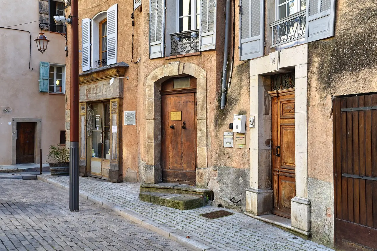 Rue des Francs-Bourgeois in Le Marais: A picturesque and historically rich shopping destination for travelers who value craftsmanship and charm Charming cobblestone street in Le Marais with pastel storefronts, flower boxes, and boutique signage in French
