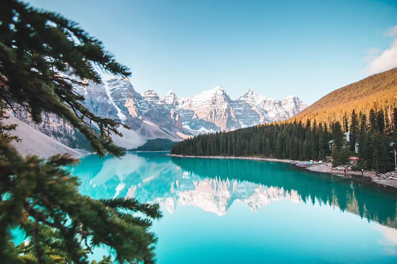 Lake Louise’s ion-rich glacial waters and vast silence make it a premier destination for wilderness-based relaxation travel. Glacial turquoise lake surrounded by pine forest and snow-dusted Rocky Mountains, no people visible