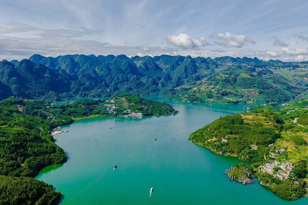 Paisaje tranquilo del Lake District con aguas tranquilas y montañas cubiertas de vegetación Lago sereno rodeado de colinas verdes en el Lake District