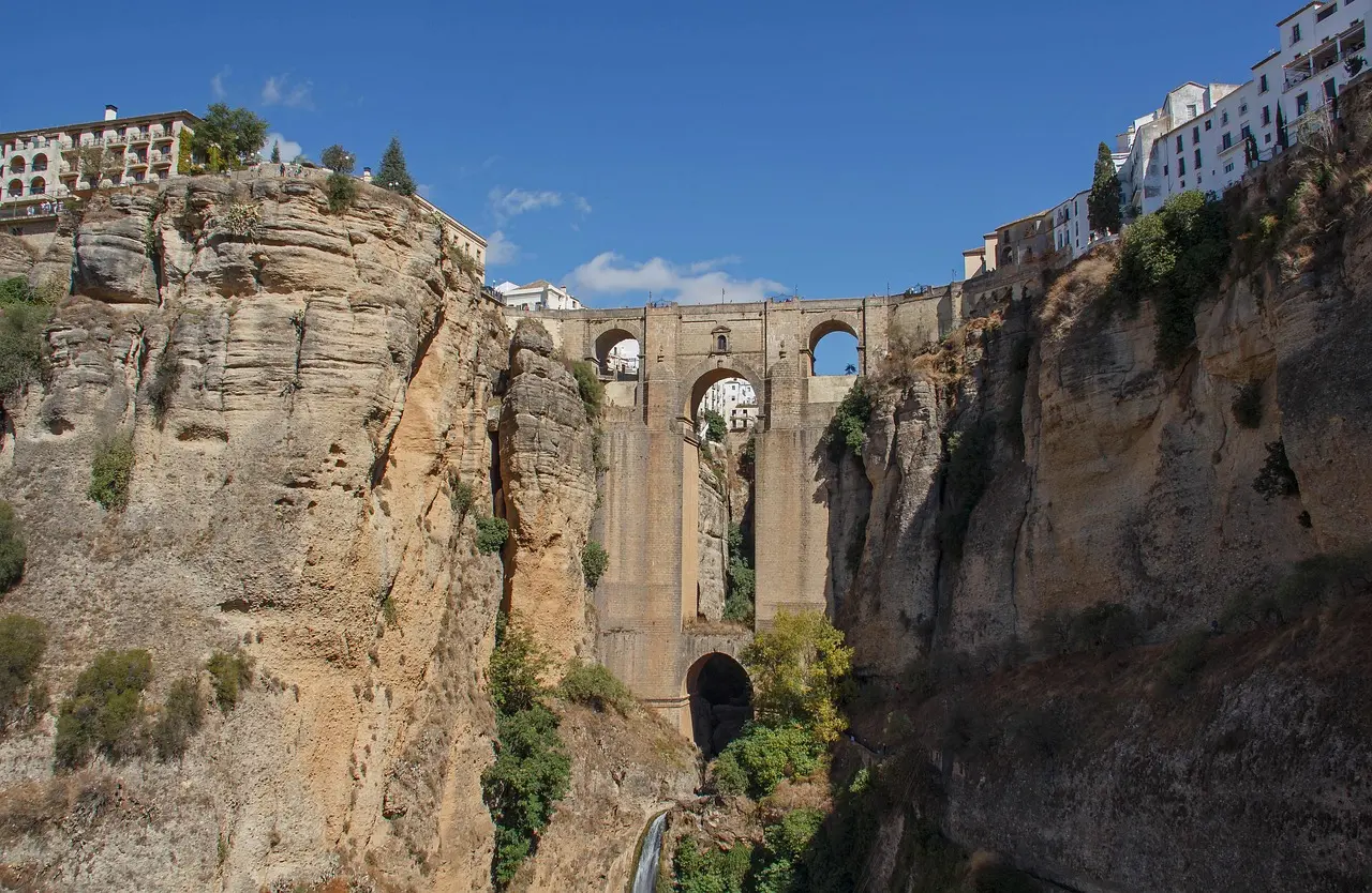 El icónico Puente Nuevo de Ronda iluminado por los últimos rayos del sol, cruzando el profundo tajo del río Guadalevín Puente Nuevo de Ronda al atardecer sobre el tajo