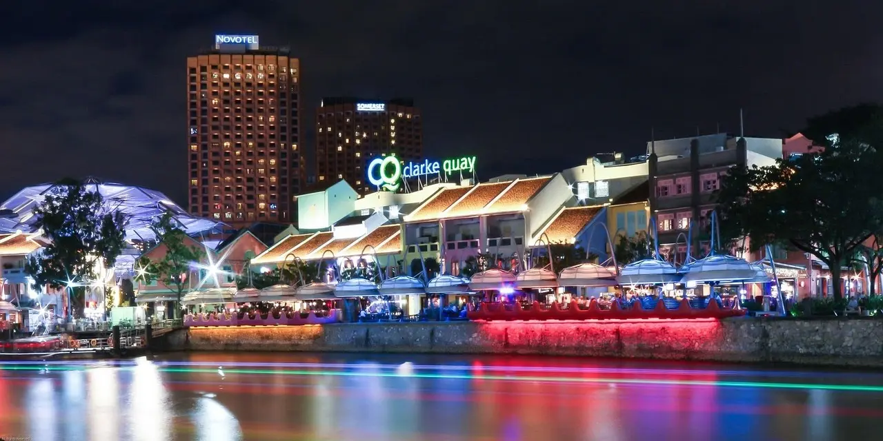 Vista nocturna de Clarke Quay con sus restaurantes iluminados a lo largo del río Singapur Río Singapur con restaurantes iluminados en Clarke Quay