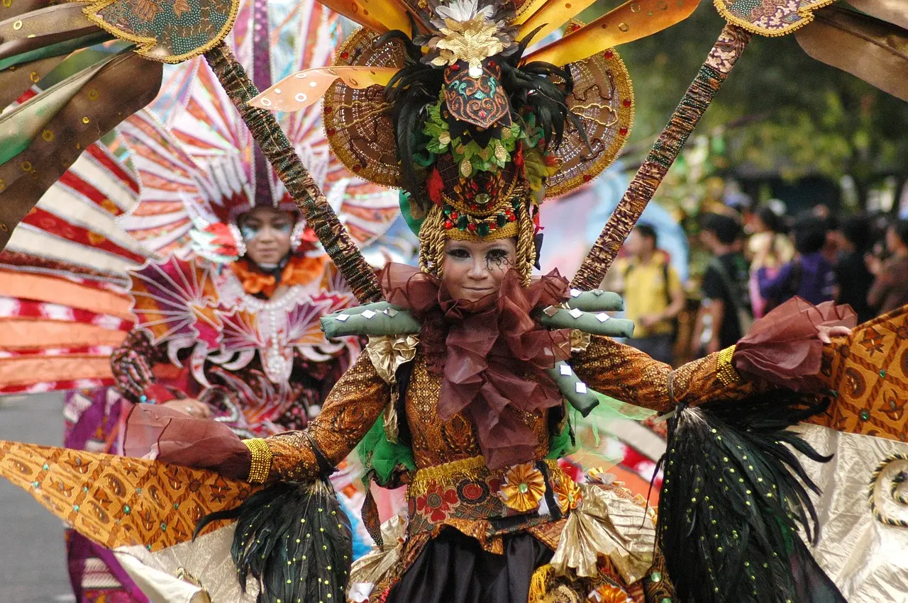 Traditional batik workshop in Ubud, Bali—using hand-carved copper tools and organic dyes Bali artisan demonstrating batik stamping with a canting tool on white cotton fabric in a shaded open-air studio