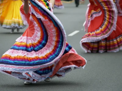 A vibrant group of dancers in traditional Oaxacan costumes performing outdoors during daylight