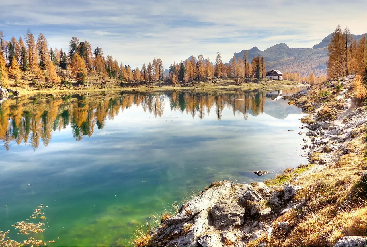 Lago Bear con aguas cristalinas reflejando picos nevados y pinos alpinos en el Parque Nacional de las Montañas Rocosas, Colorado Lago Bear con reflejo de picos nevados y pinos alpinos en el Parque Nacional de las Montañas Rocosas
