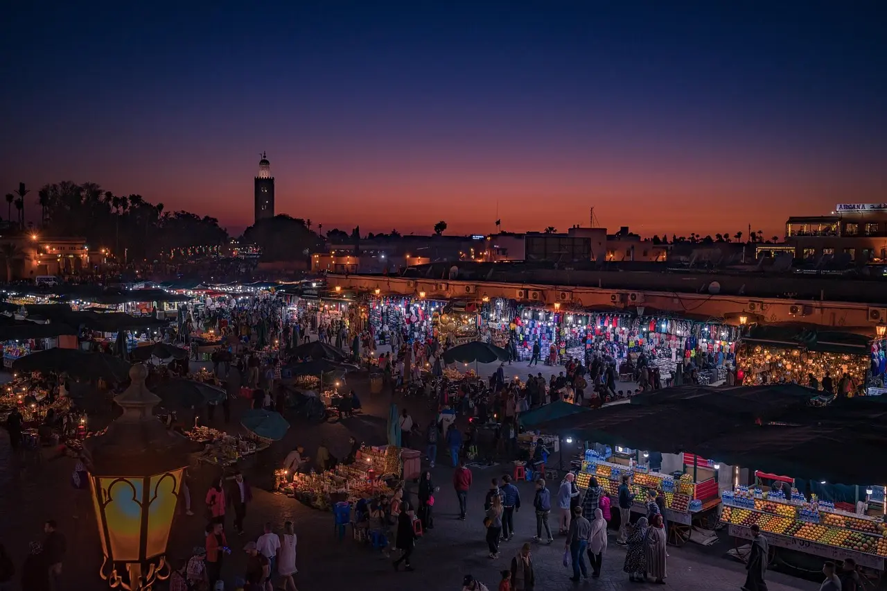 The vibrant, chaotic energy of Jemaa el-Fnaa at dusk — a living, breathing landmark that makes Marrakech one of the most dynamic travel destinations for landmark photography in Africa Jemaa el-Fnaa square in Marrakech at dusk with food stalls, lanterns, and crowd activity