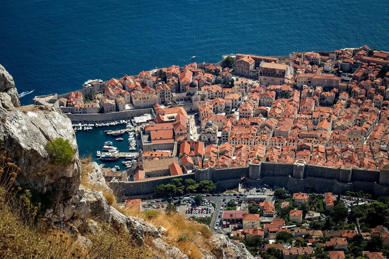 Majestic Dubrovnik city walls overlooking the Adriatic — a historic and romantic European honeymoon destination Ancient stone walls of Dubrovnik Old Town overlooking the sparkling Adriatic Sea at dusk