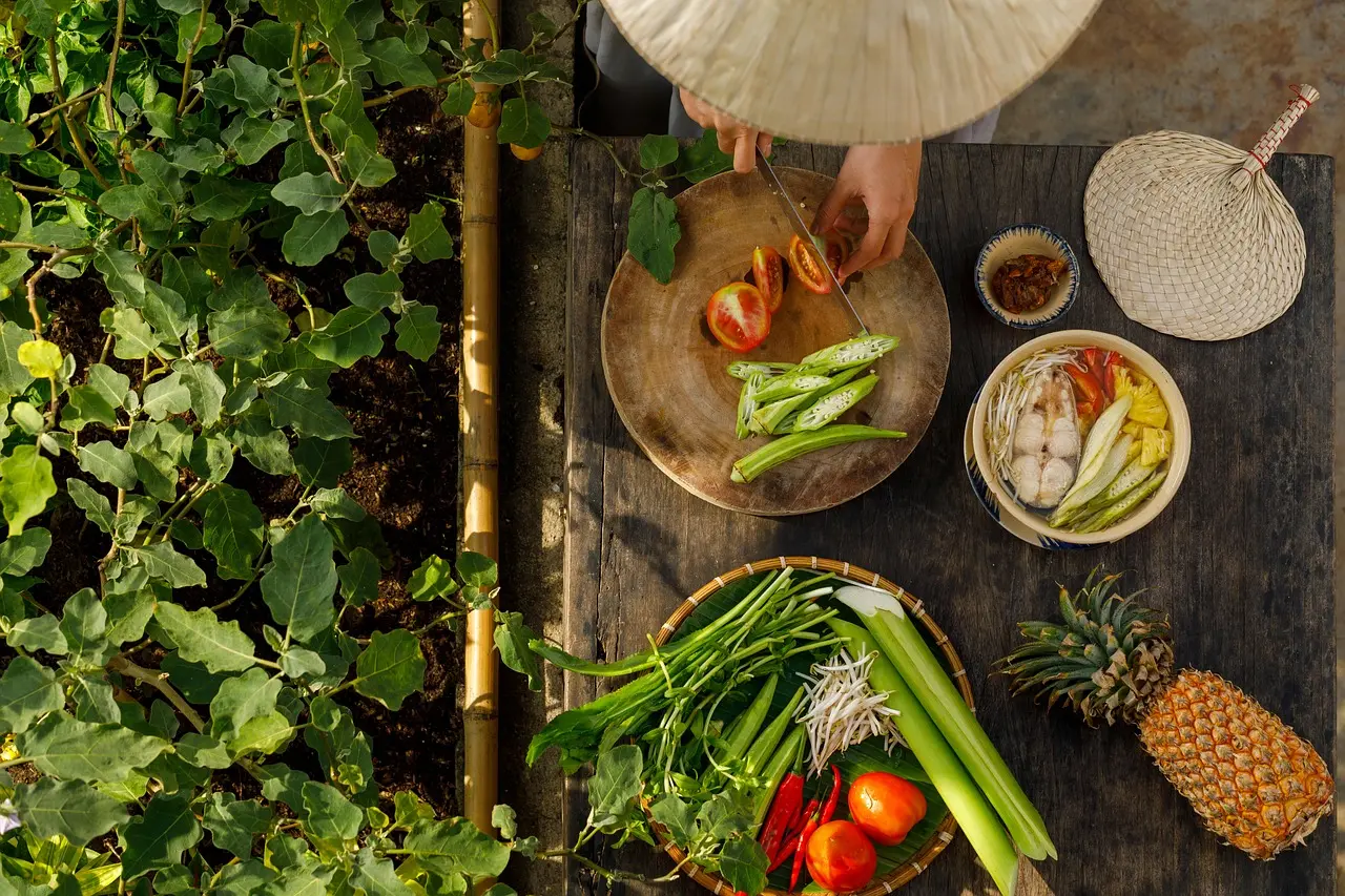 Traditional Hoi An white rose dumpling workshop in a family garden with jasmine vines and fresh shrimp paste Hand shaping white rose dumplings on bamboo steamer in Hoi An garden kitchen
