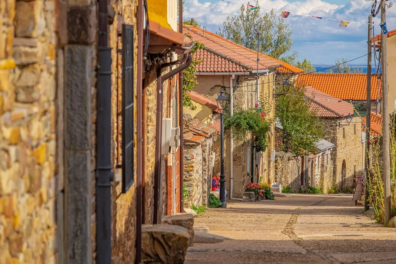 Grupo de peregrinos caminando por un tramo típico del Camino de Santiago en Galicia, con mochilas y bastones Peregrinos caminando por el Camino de Santiago en Galicia