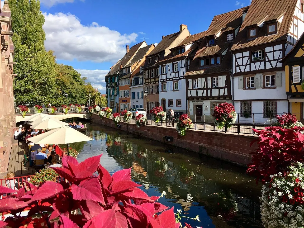 Casa tradicional alsaciana decorada con flores en el pueblo de Colmar Casa típica alsaciana con flores en Colmar