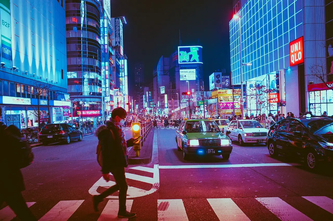 Shibuya Crossing in Tokyo: A global icon of urban shopping culture and energetic street life Aerial view of Shibuya Crossing in Tokyo with shoppers carrying branded bags and colorful street signs
