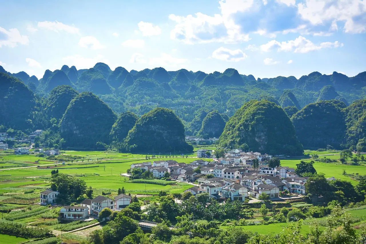 Rutas ciclistas tranquilas en el campo de Yangshuo rodeado de formaciones kársticas Ciclistas en campo rural con montañas kársticas al fondo en Yangshuo