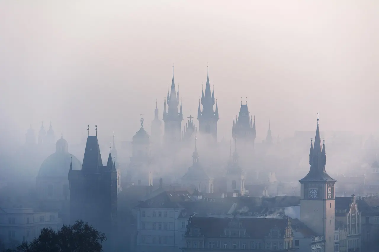 Puente de Carlos en Praga al amanecer con niebla ligera