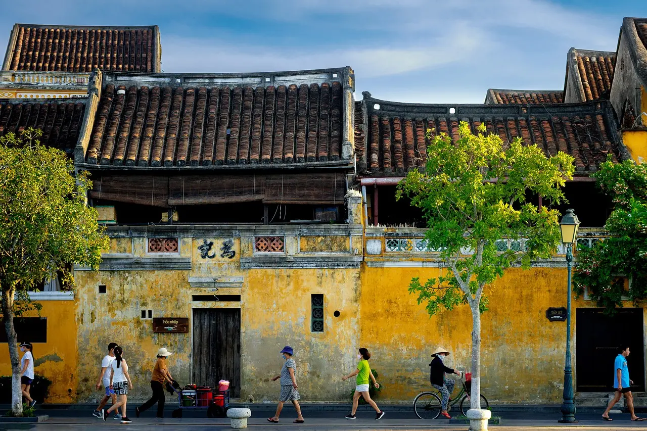 Magical ambiance in Hoi An’s lantern-lit lanes — a warm, nostalgic highlight among heartfelt honeymoon destinations in Asia Evening street scene in Hoi An Ancient Town: paper lanterns glowing above cobblestone lane, couple walking past shuttered shop fronts