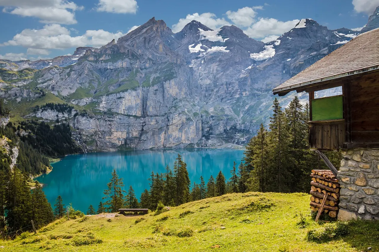 Remote turquoise alpine lake nestled in Kyrgyzstan’s Tian Shan range with snow-capped peaks and grazing horses Trekker beside turquoise alpine lake surrounded by snow-draped peaks and grazing horses near Ala-Kul