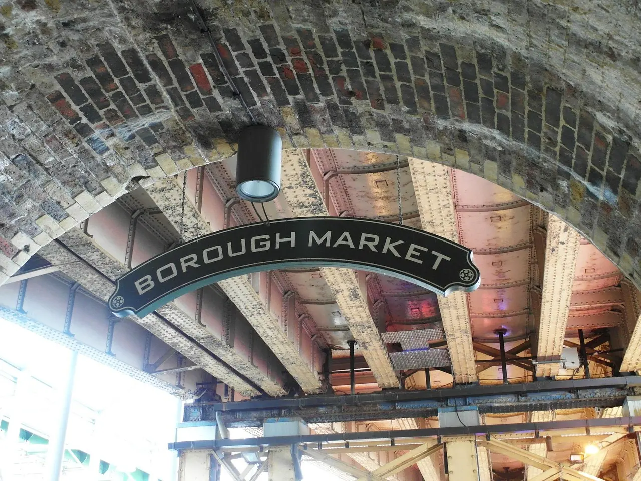Puestos coloridos de comida en Borough Market con productos frescos y visitantes